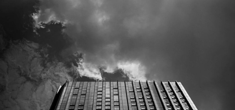 High rise office building reaches up toward a cloudy sky