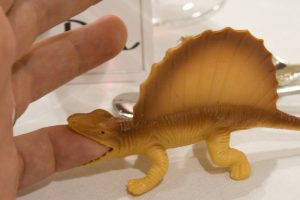 Dinosaur toy biting a finger